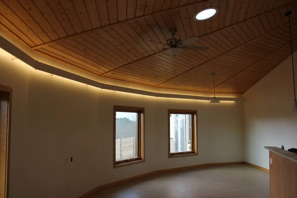 Curved room with a wood ceiling, hidden cove lighting and recessed lights