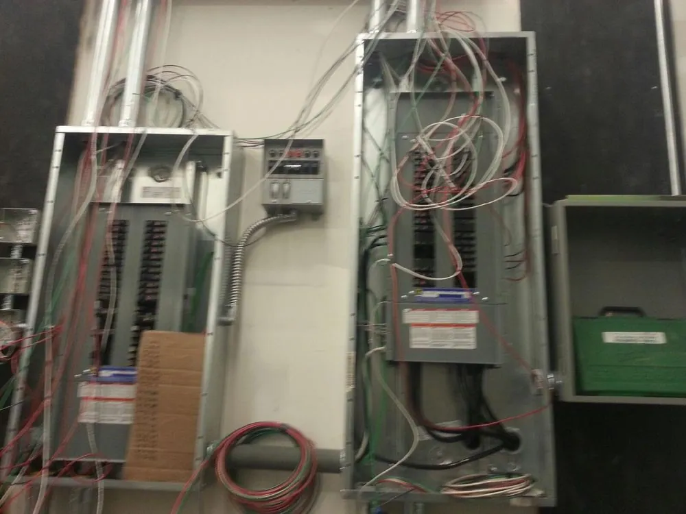 Two open electrical panels with new wiring being landed
