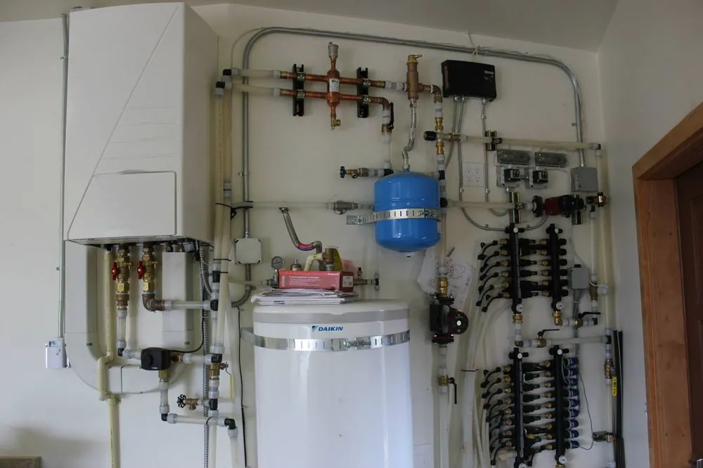 Mechanical room with a wall-hung boiler, pumps and neat conduit runs