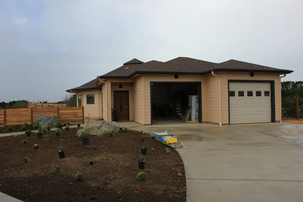 New single-story home with an open garage, landscaping just started